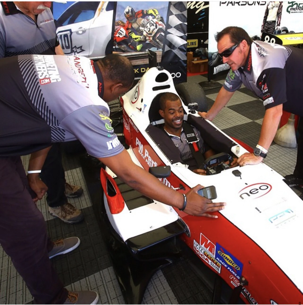 Freddie seated in a racing car with the racing team